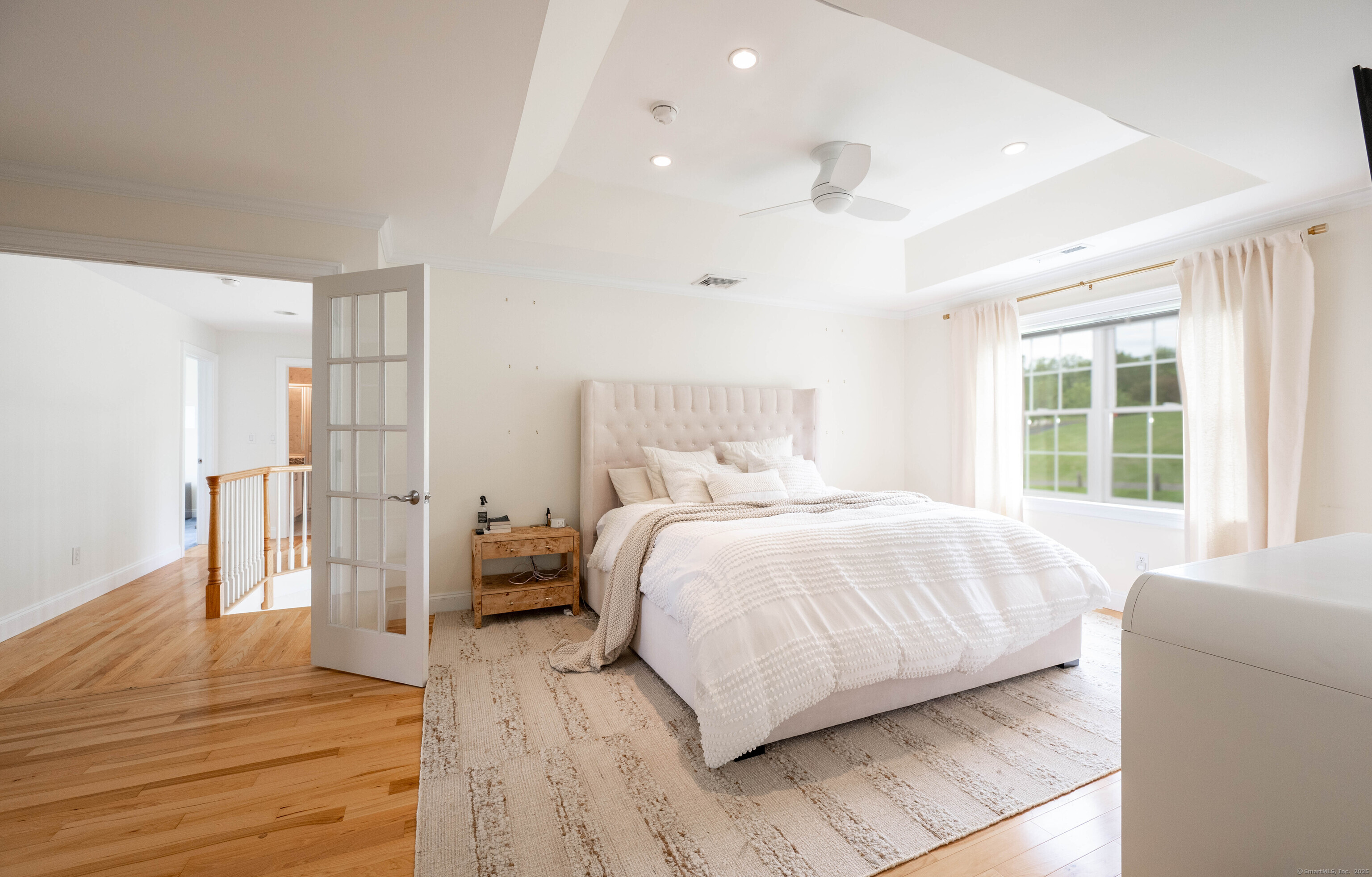 557 Upper Grassy Hill Road Woodbury, CT 06798 - Photo 15 of 40 a bedroom with a bed and wooden floor