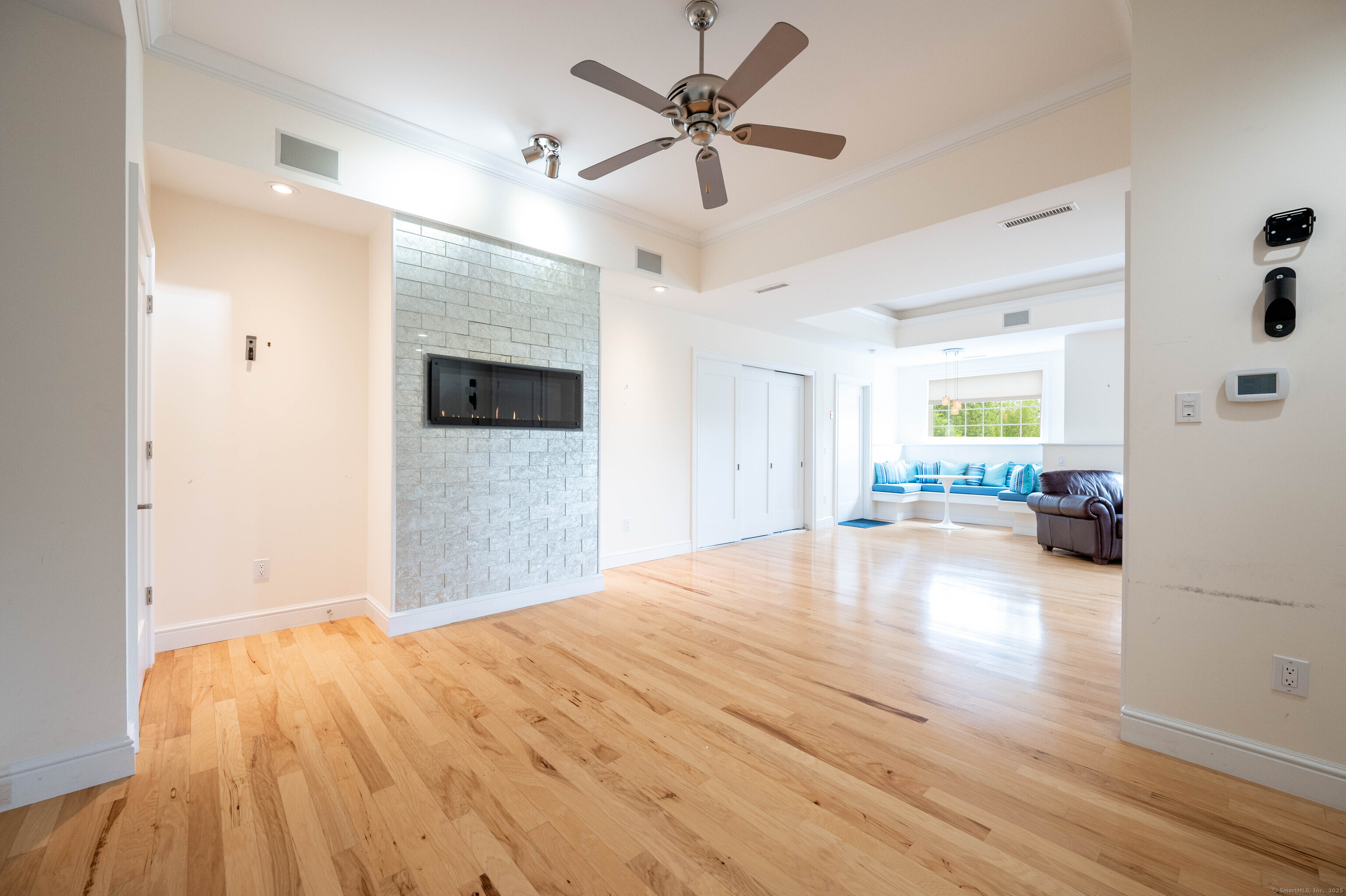 557 Upper Grassy Hill Road Woodbury, CT 06798 - Photo 31 of 40 a big room with wooden floor and a ceiling fan