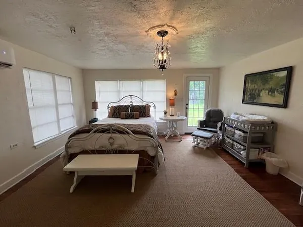 a bedroom with bed couch and window