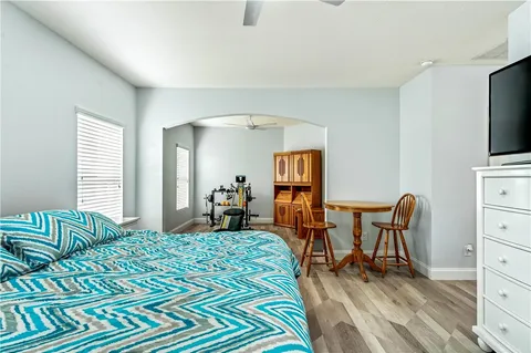 a bedroom with a bed a chair and glass windows