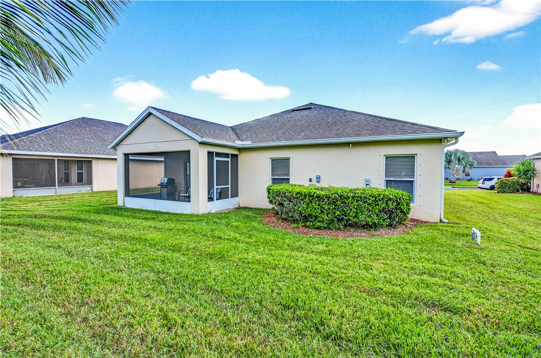 535 Valencia Circle Southwest Vero Beach, FL 32968 - Photo 28 of 36 a view of a house with a yard potted plants and a yard