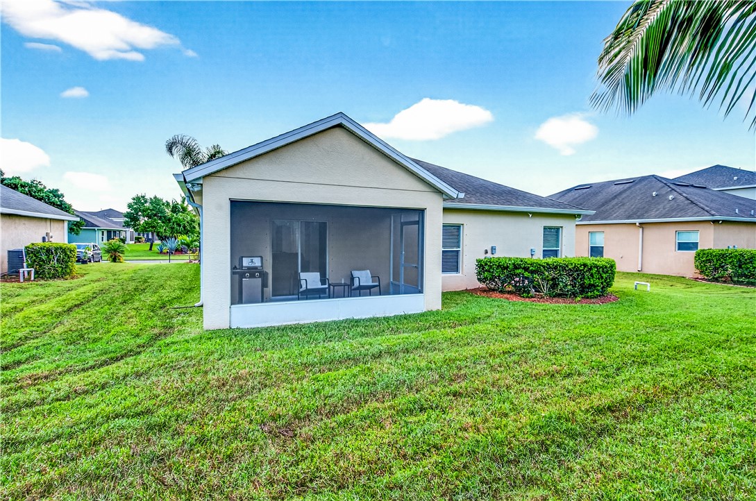 535 Valencia Circle Southwest Vero Beach, FL 32968 - Photo 29 of 36 a view of a house with a yard and potted plants