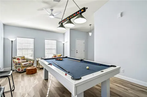 a room with furniture pool table and windows