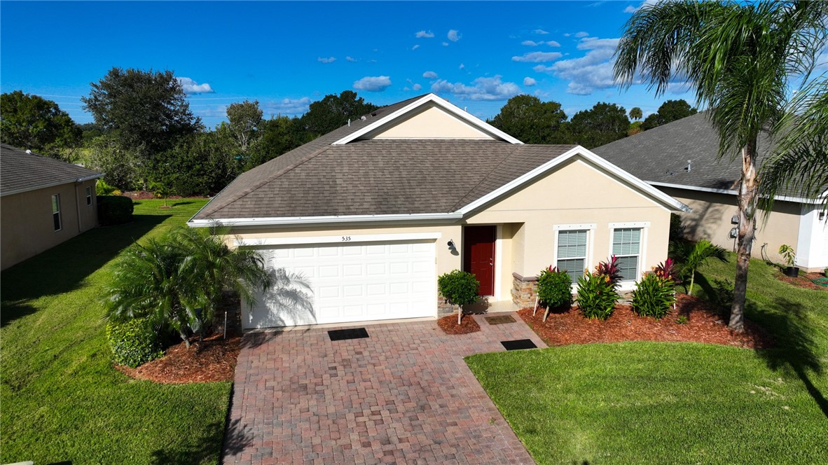 535 Valencia Circle Southwest Vero Beach, FL 32968 - Photo 31 of 36 a view of house with garden and tall tress