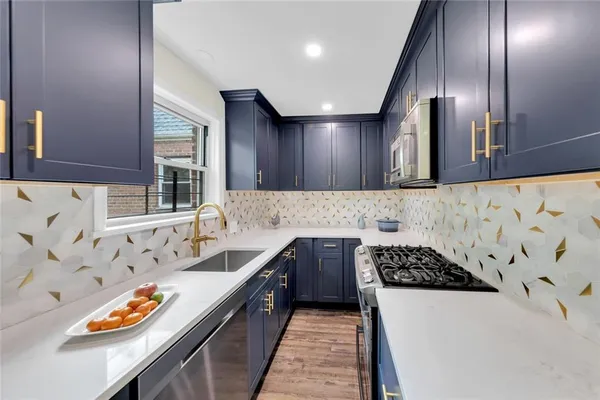 a kitchen with stainless steel appliances granite countertop a sink stove and cabinets