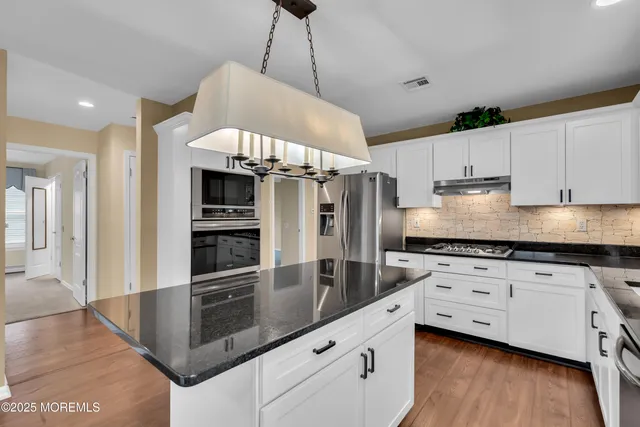 a kitchen with stainless steel appliances granite countertop a stove a sink and a refrigerator