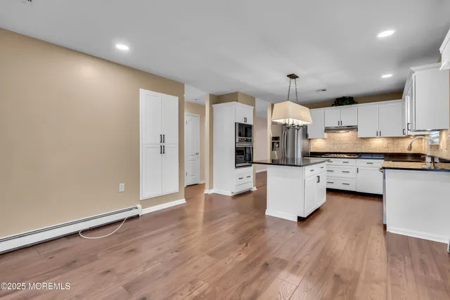 an open kitchen with white cabinets and stainless steel appliances
