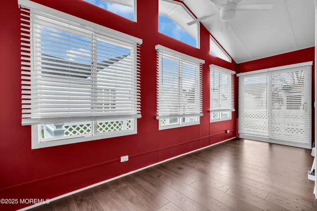 a view of a room with wooden floor and windows