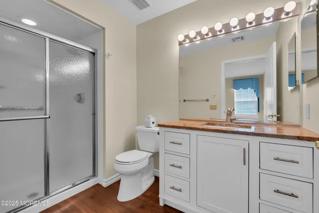 a spacious bathroom with a granite countertop sink a toilet and a mirror