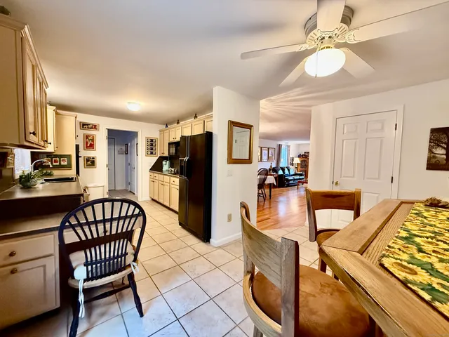 a view of a dining room with furniture and chandelier fan