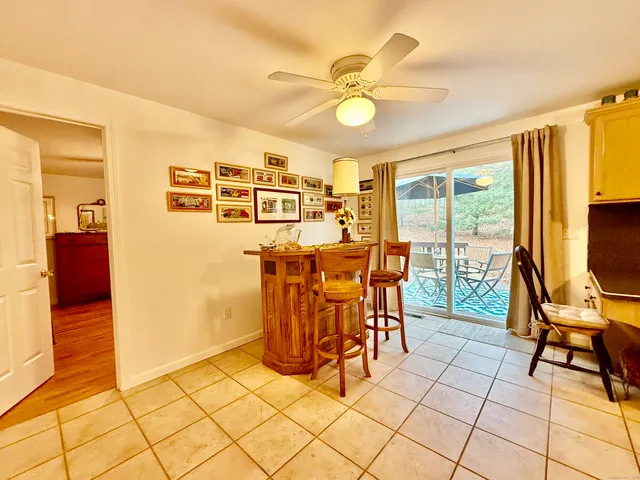 a view of a dining room with furniture and chandelier fan