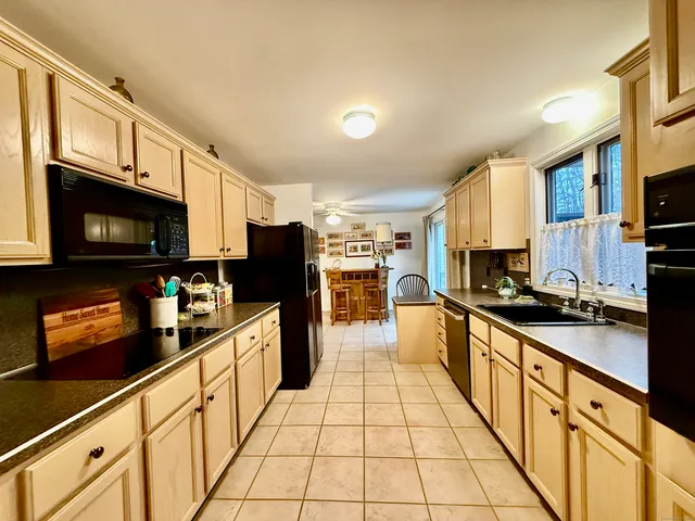 a view of a dining room and livingroom with furniture wooden floor a chandelier