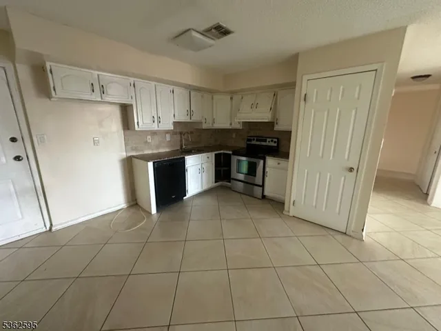a kitchen with a sink a refrigerator and cabinets