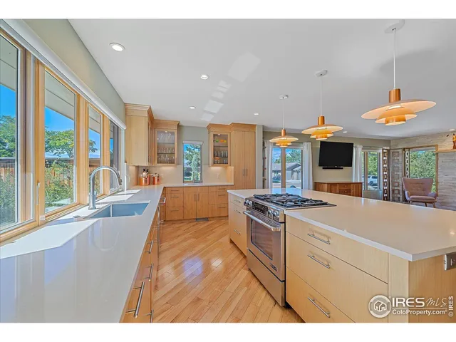 a open kitchen with stainless steel appliances granite countertop a stove and a view of living room