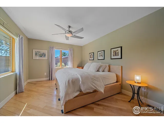 a bedroom with a bed a table and painting on the wall