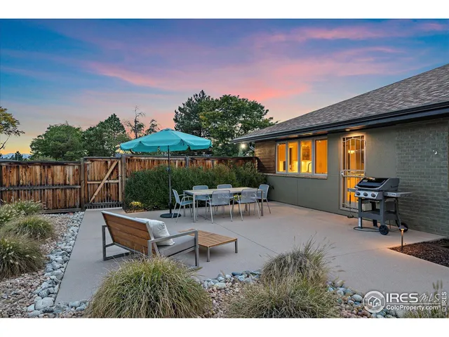 a backyard of a house with table and chairs