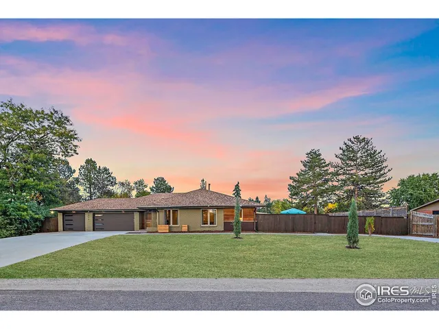 a view of a house with a big yard and a large tree