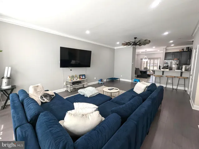a living room with furniture kitchen view and a flat screen tv