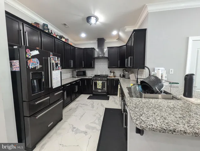 a kitchen with stainless steel appliances granite countertop a refrigerator and a sink
