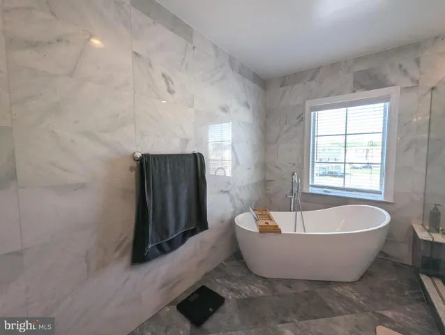 a white tub sitting in a bathroom next to a window