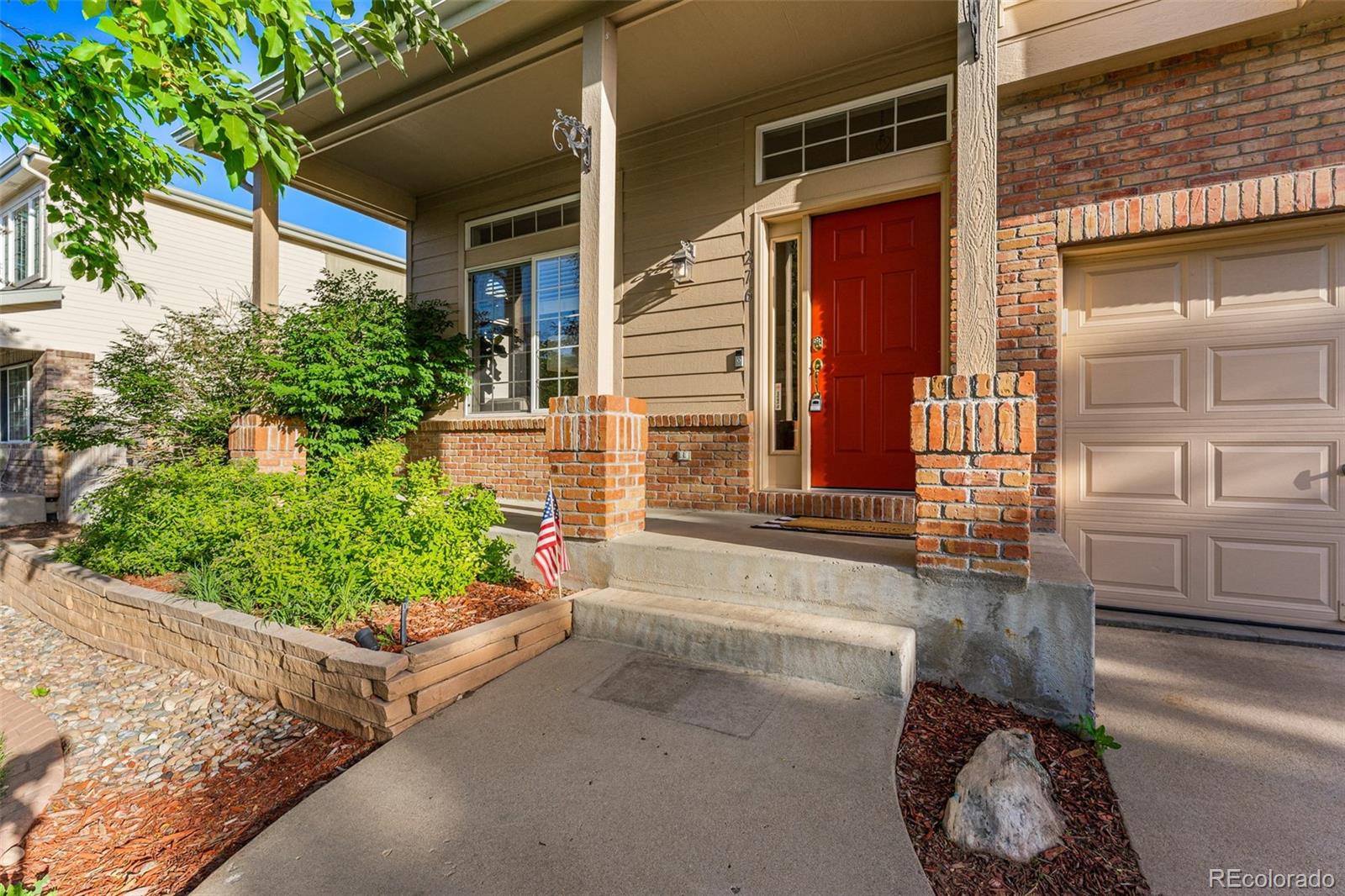 276 East Fair Lane Centennial, CO 80121 - Photo 4 of 38 a front view of a house with a yard and flowers