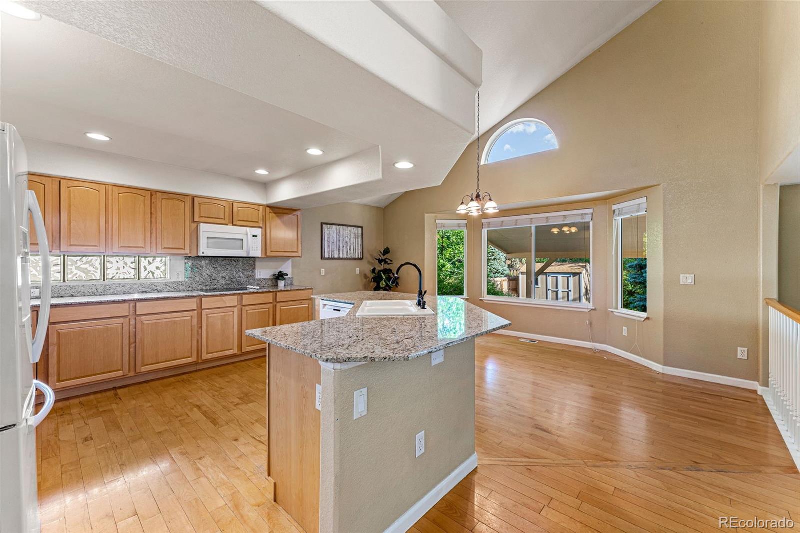 276 East Fair Lane Centennial, CO 80121 - Photo 9 of 38 a large kitchen with kitchen island a large counter top space a sink stainless steel appliances and cabinets