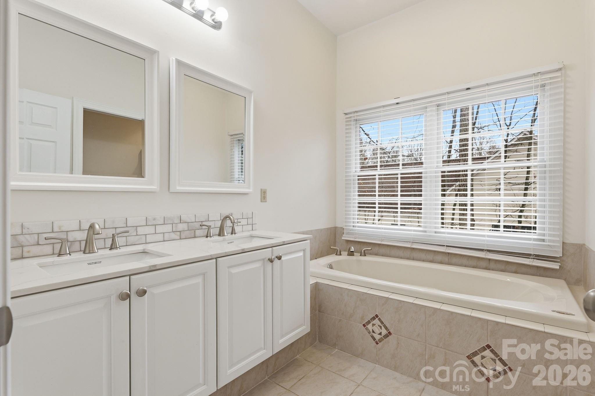 157 Byers Road Troutman, NC 28166 - Photo 16 of 32 a bathroom with a granite countertop sink mirror and a bathtub