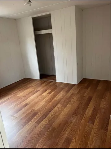 a view of an empty room with closet and a window