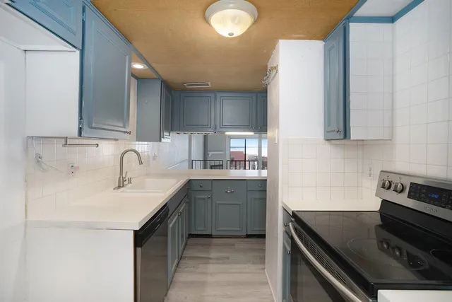 a kitchen with a sink stove and cabinets