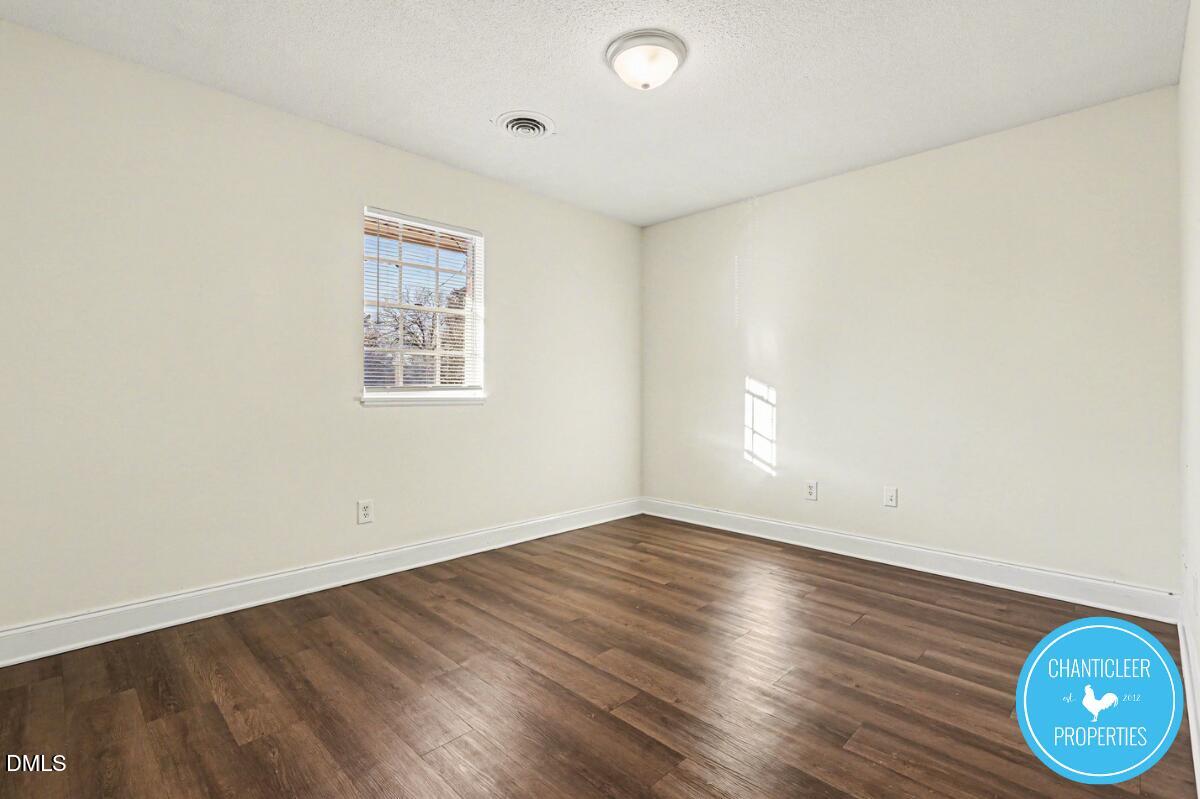 115 Florence Street, Unit 13 Graham, NC 27253 - Photo 18 of 29 an empty room with wooden floor and windows