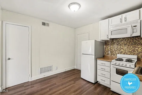 a kitchen with white cabinets and white appliances