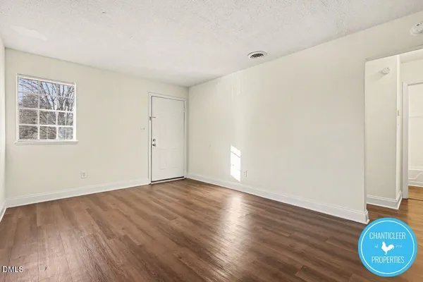 a view of an empty room with closet and wooden floor
