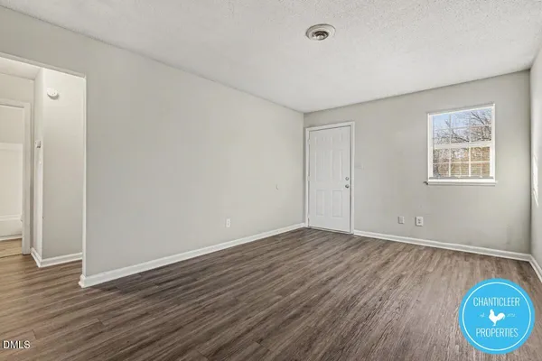 a view of an empty room with wooden floor