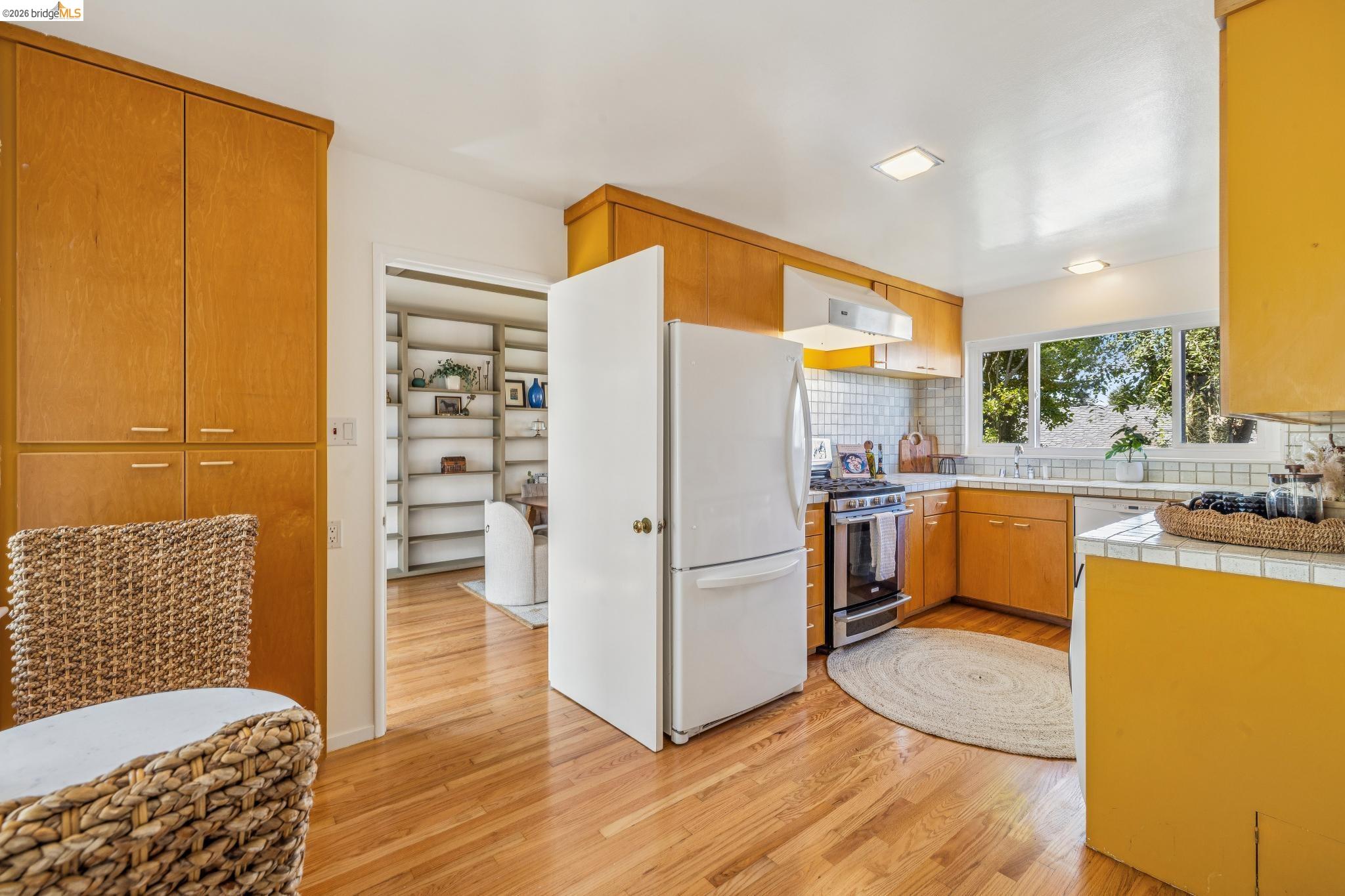 1024 Overlook Road Berkeley, CA 94708 - Photo 22 of 41 Kitchen featuring wood-finish cabinetry, stainless steel range, built-in dishwasher, and a window with outdoor scenery
