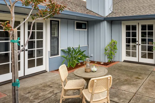 a view of a house with a large window and potted plants