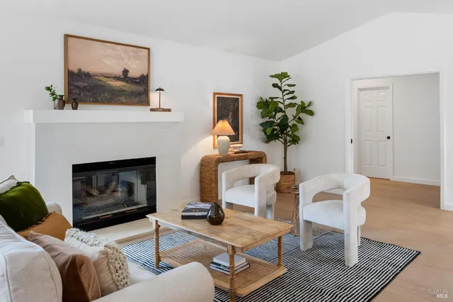 a living room with furniture a fireplace and window