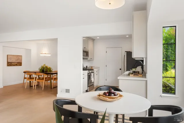 a dining room with furniture and a kitchen view