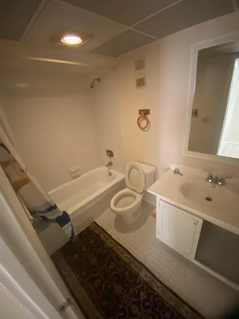 a bathroom with a granite countertop sink a toilet and a mirror