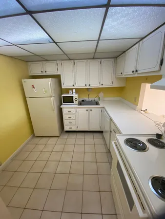a kitchen with a sink a stove and white cabinets