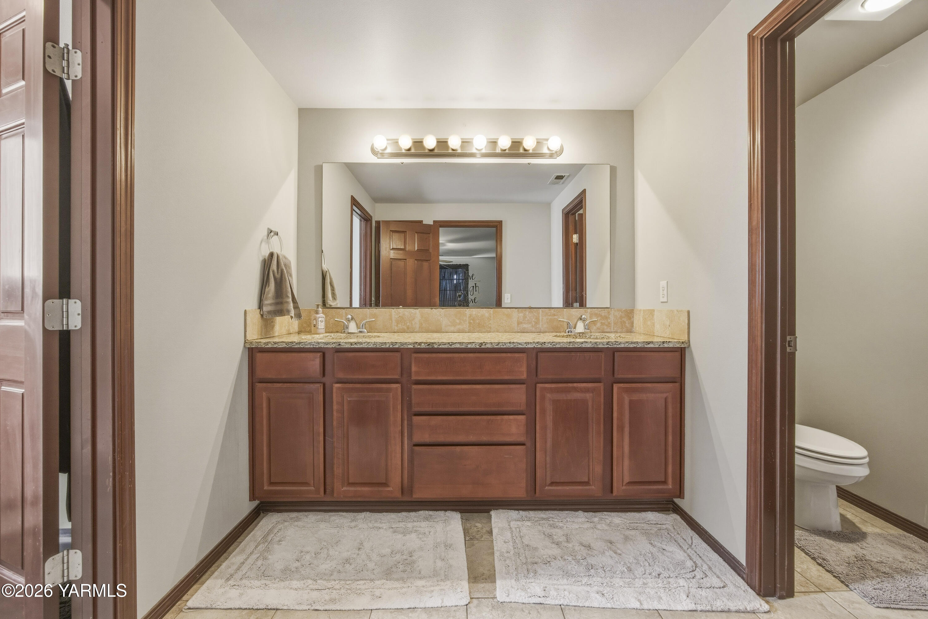 2050 Olmstead Road Grandview, WA 98930 - Photo 15 of 60 a bathroom with a granite countertop sink a toilet and a mirror