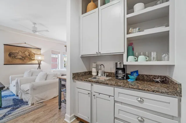 a kitchen with granite countertop white cabinets and white appliances
