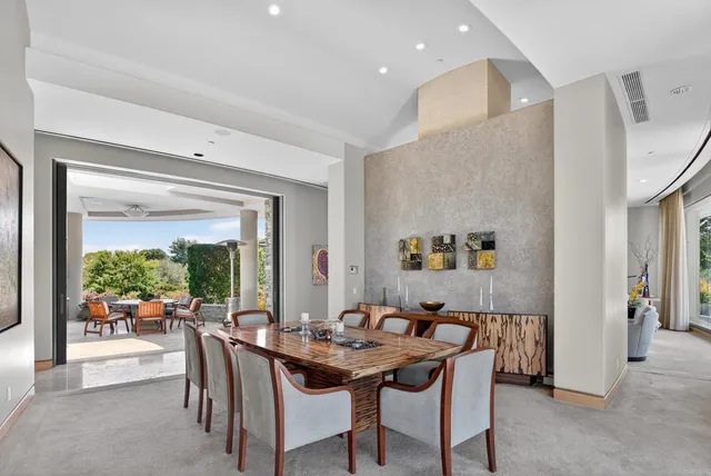 a dining room with furniture and a floor to ceiling window
