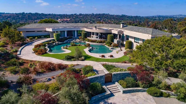 an aerial view of a house with a garden and lake view
