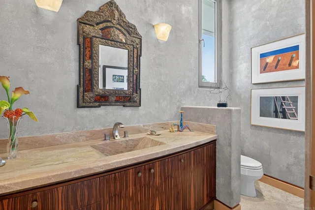 a bathroom with a sink a toilet and mirror