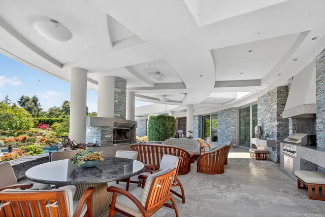 a living room with furniture kitchen view and a large window