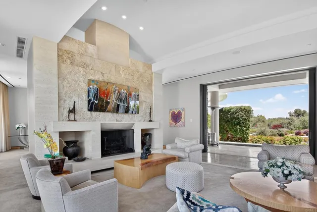 a living room with furniture a fireplace and a large window
