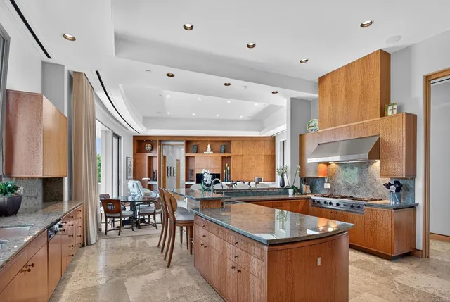 a kitchen with stainless steel appliances granite countertop a sink and a refrigerator