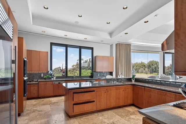 a kitchen with stainless steel appliances kitchen island granite countertop a sink and cabinets