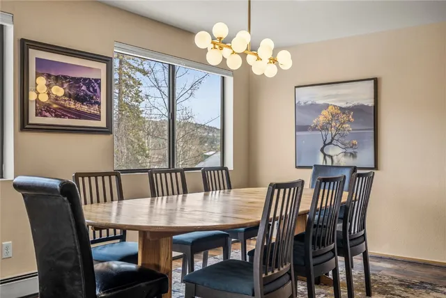 a view of a dining room with furniture a chandelier and wooden floor