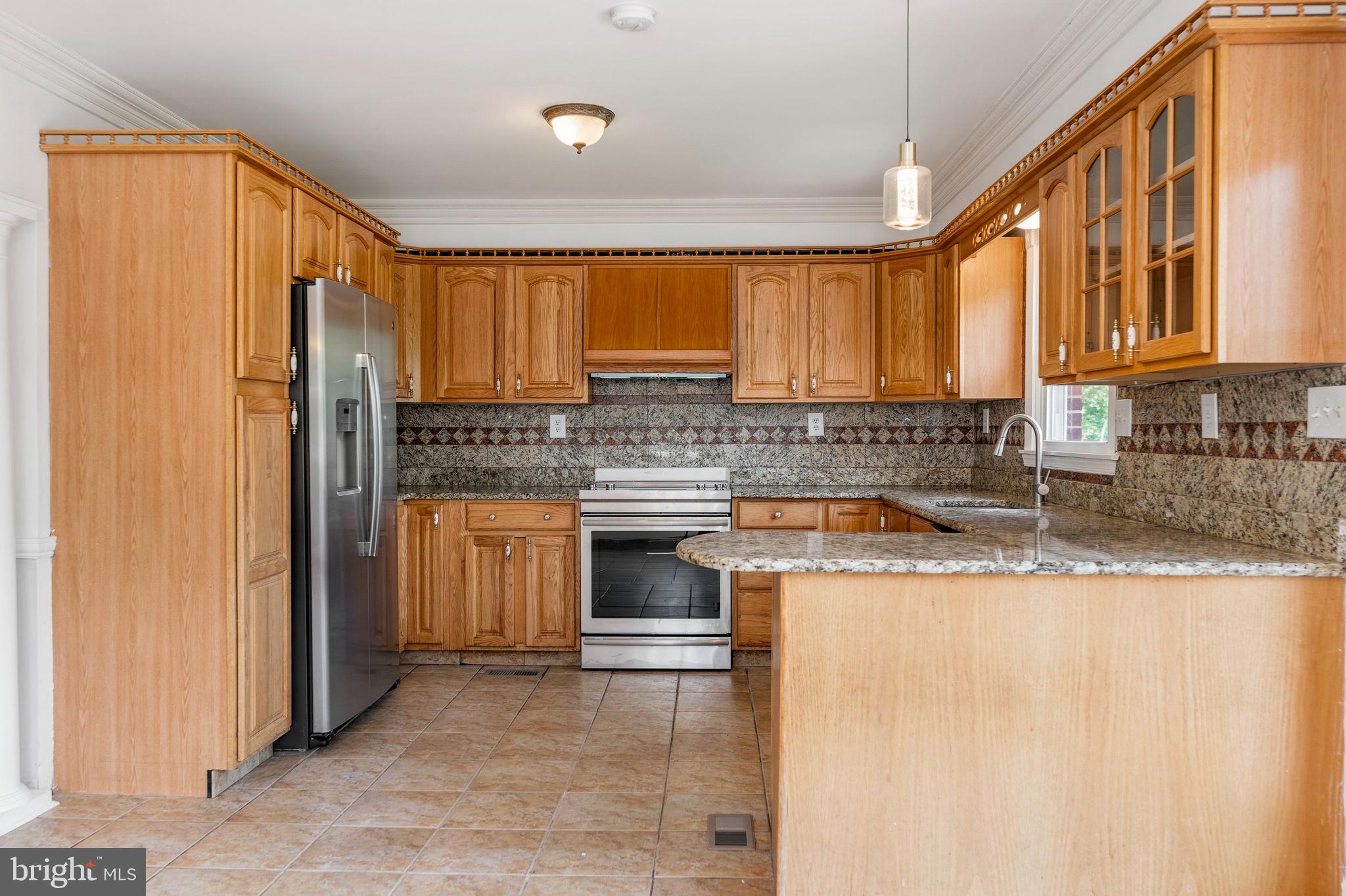 11325 Bacon Race Road Woodbridge, VA 22192 - Photo 13 of 54 a kitchen with stainless steel appliances granite countertop a stove a sink and a refrigerator